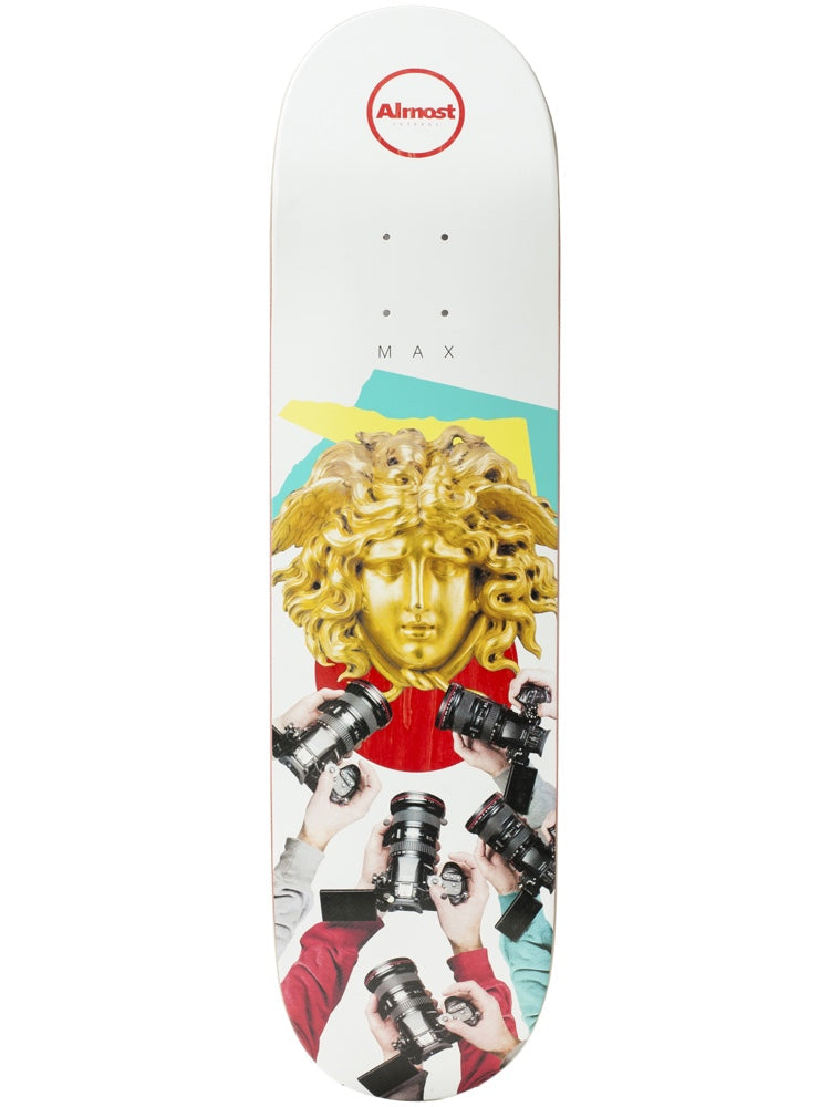 Almost Max Cut & Paste R7 8.125 skateboard deck: Collage of a gold Medusa head sculpture against red, yellow and teal shapes, surrounded by hands holding cameras, on a white deck. Almost logo roundel at the top and spaced 'MAX' lettering.