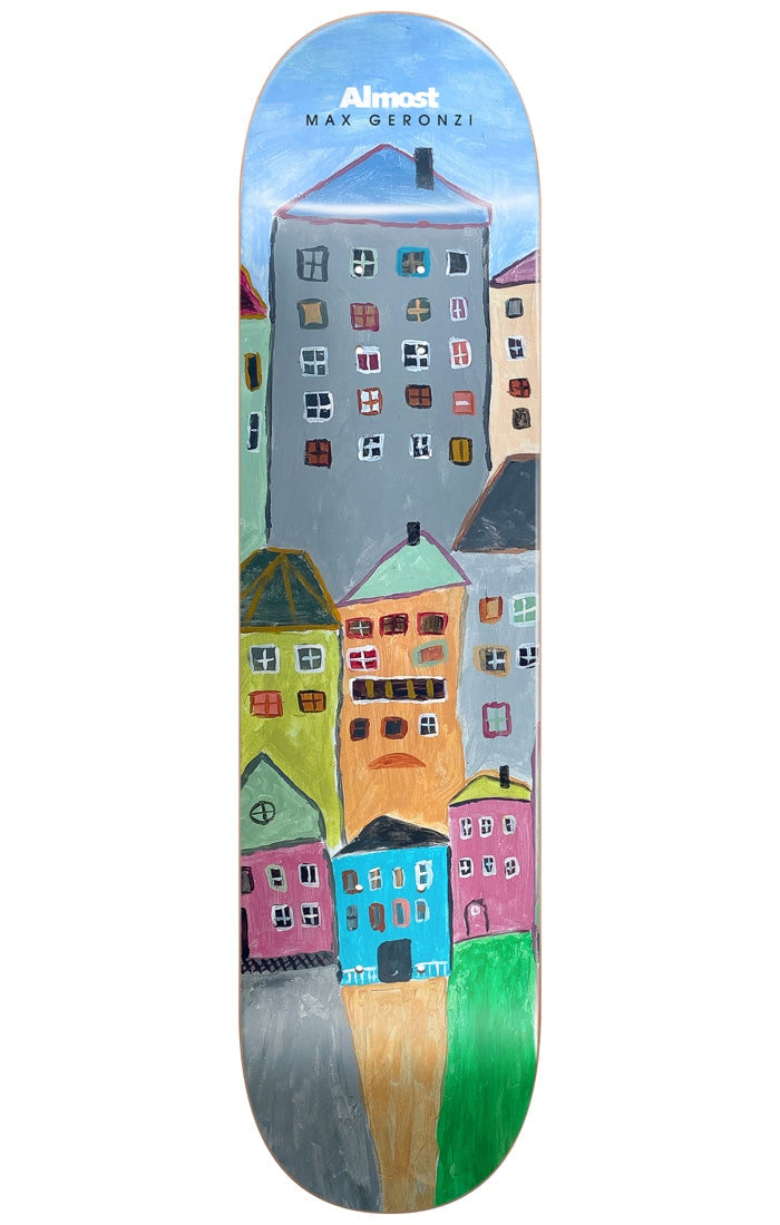 Almost Max Places R7 LEFT 8.5 skateboard deck: Painted naive-style picture of tall, crooked houses in grey, orange, green, pink and blue stacked up under a pale blue sky. 'Almost' and 'Max Geronzi' printed in white at the top.