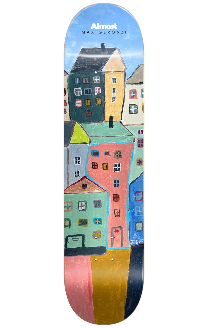 Almost Max Places R7 RIGHT 8.25 skateboard deck: Naive acrylic-style painting of a tall cluster of colourful houses with small windows under a blue sky, in greens, pinks, yellow and blue, with the brand and rider name in white at the top.