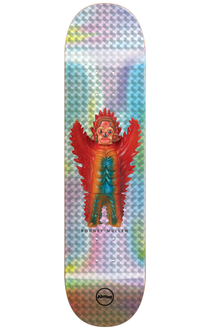 Almost Mullen Haroshi Monster Super Sap R7 7.75 & 8.0 skateboard deck: Photo of a winged red, orange and teal vinyl monster toy with three eyes, standing centrally on a holographic silver foil deck with a chequered pattern.