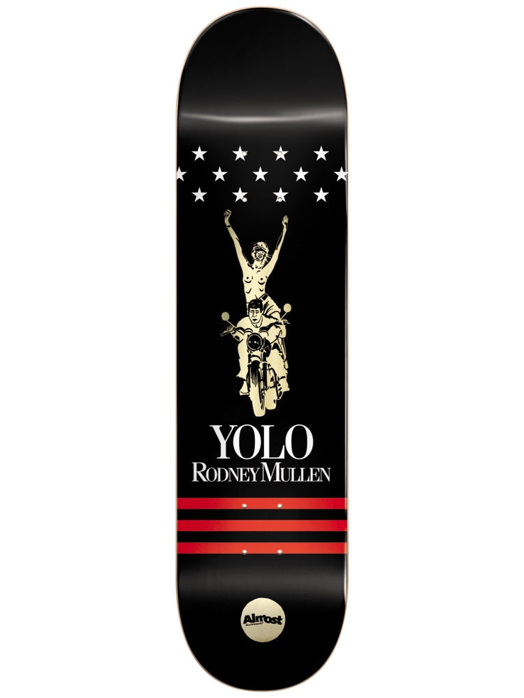 Almost Mullen Luxury Super Sap R7 7.75 skateboard deck: A cream line drawing of a nude woman raising her arms while riding pillion on a motorcycle with a male rider, below a row of white stars. 'YOLO Rodney Mullen' and three red stripes sit below on a black deck.