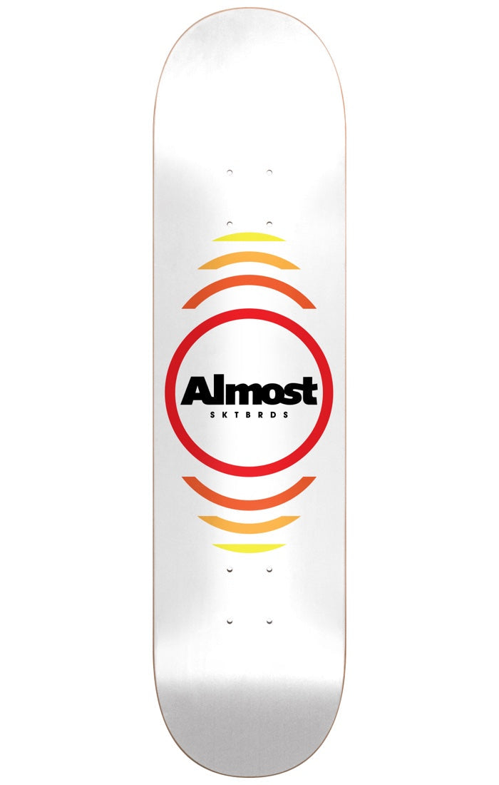 Almost Reflex WHITE 7.75 skateboard deck: A red ring around a black Almost SKTBRDS logo, with concentric arcs fading from red through orange to yellow above and below it, on a plain white deck.