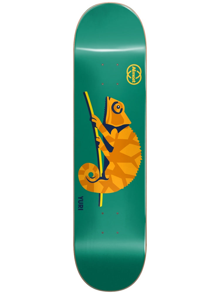 Almost Yuri Animals R7 8.125 skateboard deck: A geometric, faceted orange chameleon with a curled tail clings to a yellow and green branch on a teal deck, with the Almost logo at the top and 'YURI' near the bottom.