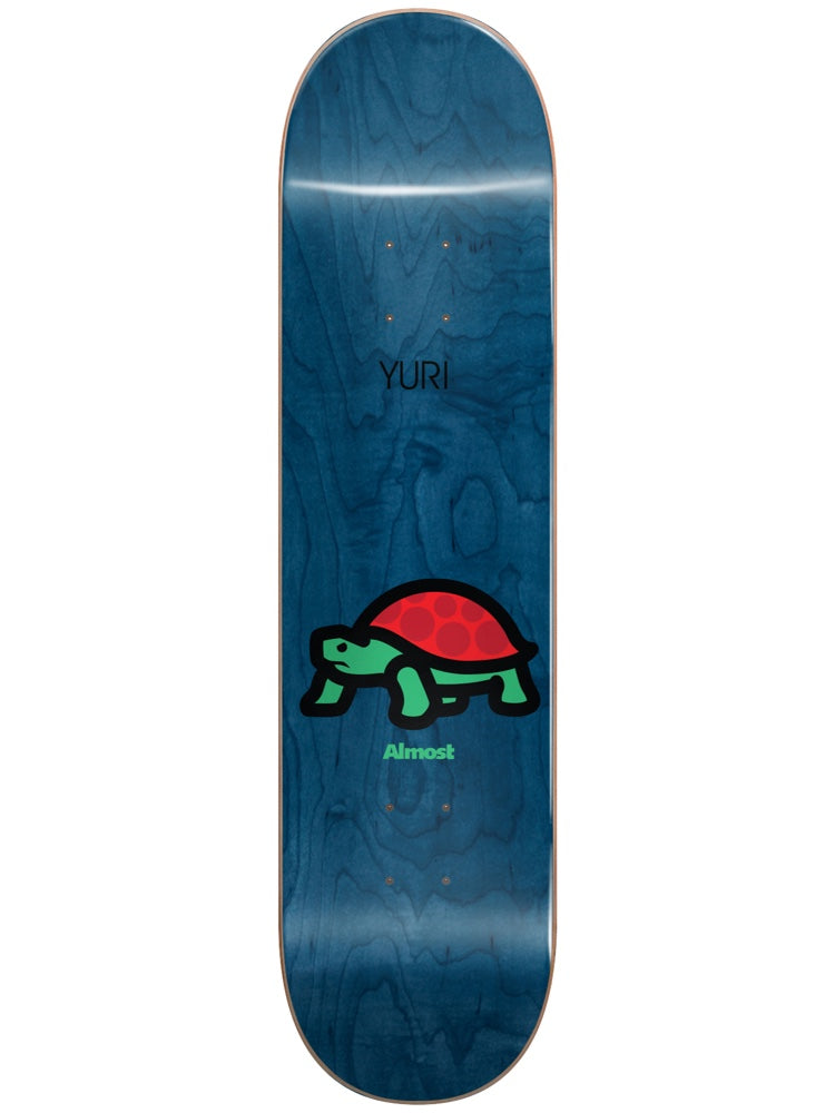 Almost Yuri Mean Pets Impact Light 8.375 skateboard deck: Blue woodgrain-stained deck with a simple cartoon tortoise with a red shell and green body and legs, outlined in black, with the rider name above and Almost logo below.
