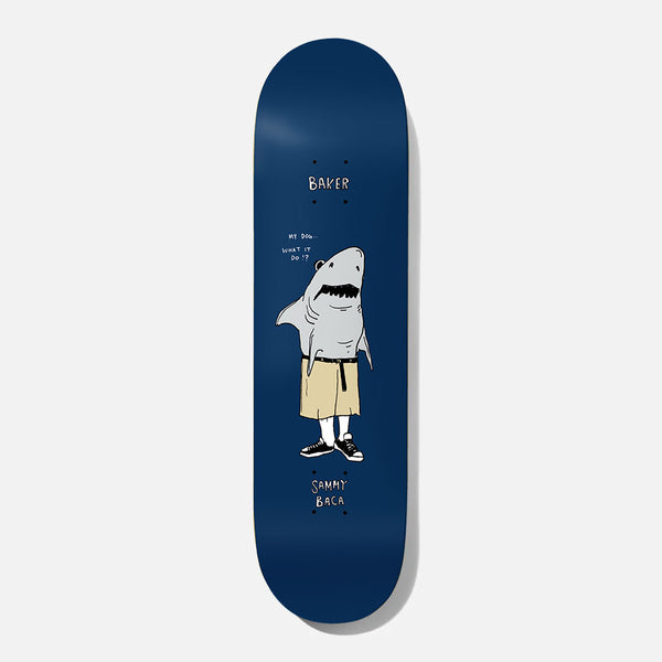 Baker Baca What It Do 8.125 skateboard deck: A cartoon shark standing upright in khaki shorts, white socks and black trainers, with a speech bubble asking what it do, on a navy deck. Baker at the nose and the rider name at the tail in hand lettering.