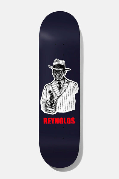 Baker Reynolds Take the Cannoli 8.5 skateboard deck: Black-and-white inked gangster in a fedora and pinstripe suit pointing a revolver at the viewer, on a navy deck with REYNOLDS in red lettering below.