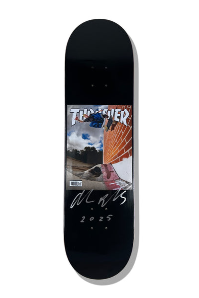Baker Reynolds Thrasher Cover 8.25 (Signed) skateboard deck: Black deck with a small panel styled as a Thrasher magazine cover, showing a skater in blue mid-air over a brick wall and gap, with a barcode. A silver signature and 2025 are written beneath.