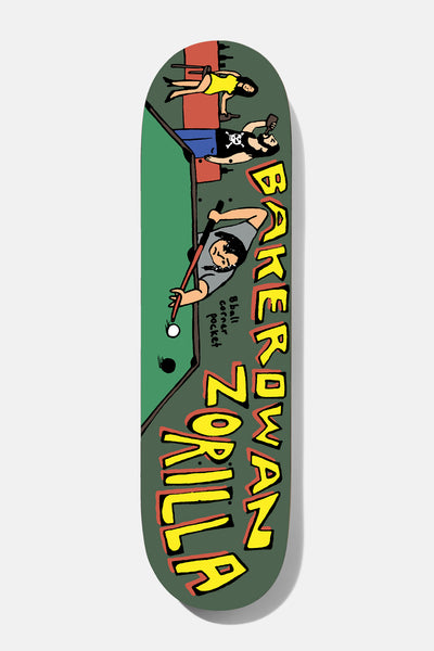 Baker Rowan 8 Ball Corner Pocket 8.5 skateboard deck: A naive cartoon of a man leaning over a green pool table to take a shot, with a skull-shirted man holding a drink and a woman in a yellow dress behind. Chunky yellow lettering with red outline runs up the side on a dark green-grey deck.