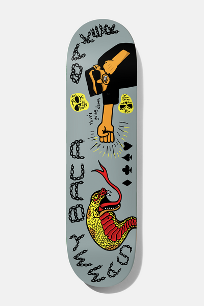 Baker Sammy Baca Going Down 8.25 skateboard deck: Sunglasses-wearing man in black punching with a fist, with yellow skulls, card suits and a yellow and red snake, plus chain-link lettering of the rider name, on grey.