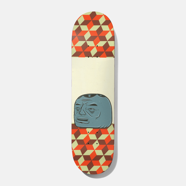 Baker Spanky Barry 8.5 skateboard deck: Grumpy blue-grey blocky head with a lined face and open mouth, drawn in a folk-art style, sitting on a cream band between two panels of isometric cube pattern in orange, brown and pale green.