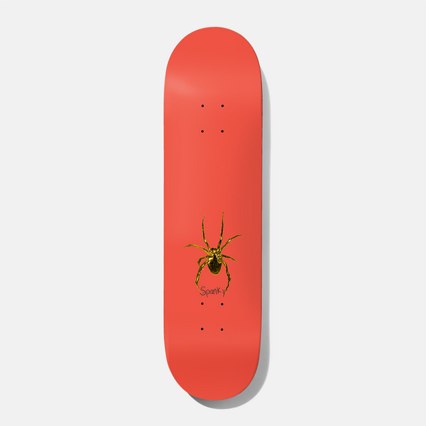 Baker Spanky Eraser Head 8.25 skateboard deck: Small gold-brown spider near the tail of a plain coral-red deck, with the rider name 'Spanky' handwritten beneath it.