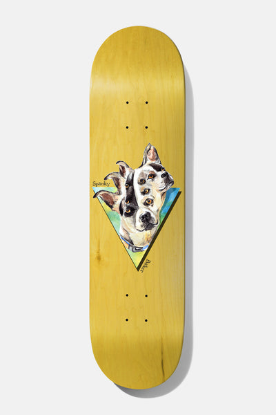 Baker Spanky Seasons B2 8.0 skateboard deck: A painted multi-eyed dog head, with several overlapping faces, sits in a blue-green and yellow triangle on a natural yellow-stained deck, with small handwritten 'Spanky' and 'Baker' text at its edges.