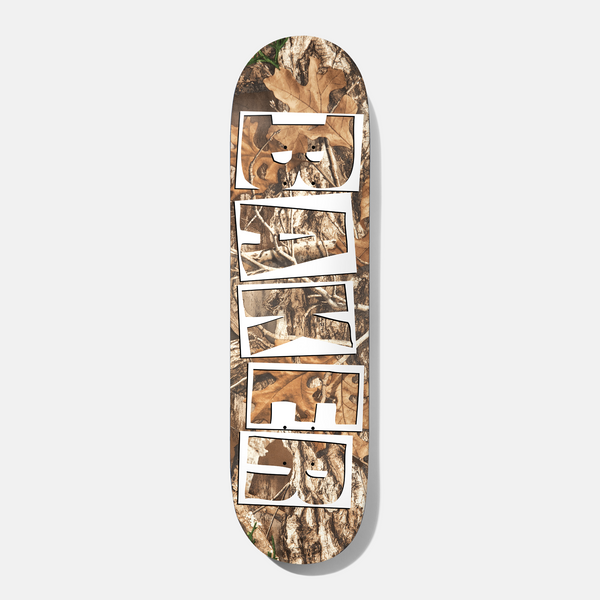 Baker Tyson Trees 8.5 skateboard deck: Realistic woodland camouflage photo print of leaves, bark and branches, with the Baker logo in stacked white outlined block letters cut out down the length of the deck.