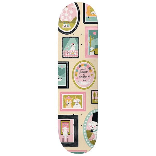 Birdhouse Armanto Alma 8.25 skateboard deck: A gallery wall of framed illustrations of a fluffy white dog in different settings, including dining at a table, in a desert, and wearing a hat, with a central oval frame reading 'Lizzie Armanto x Birdhouse x Alma' on a cream board.