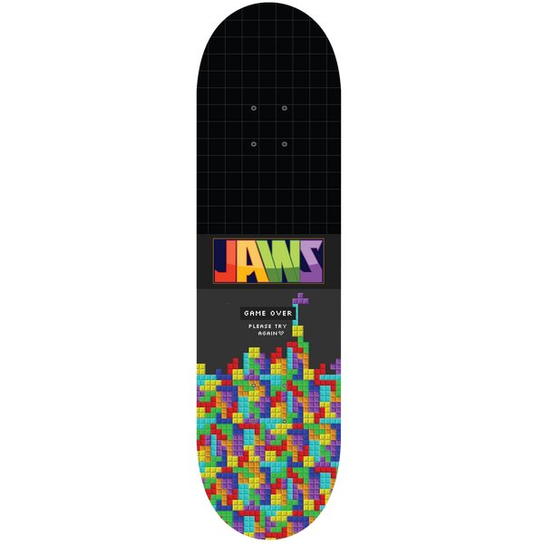 Birdhouse Jaws Game Over 8.25 skateboard deck: Black deck with a faint grid, a multicoloured 'JAWS' logo and a heap of stacked falling-block puzzle pieces rising from the tail, with a 'Game Over' message in pixel text.