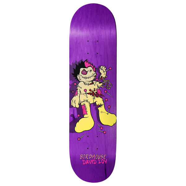 Birdhouse Loy Pinman 8.475 skateboard deck: A stitched cartoon voodoo doll with spiky black and pink hair, a button eye, torn patches and pins stuck in its body, standing on a purple stained deck. Brand and rider name appear at the bottom.