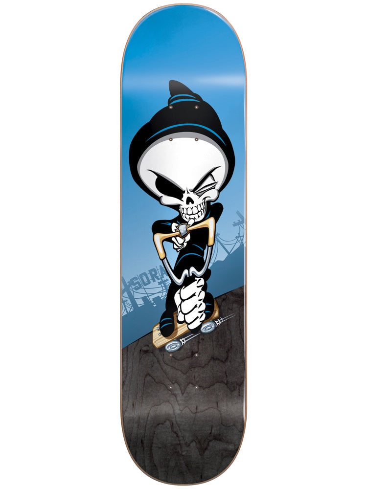 Blind Sora Reaper Slingshot R7 7.75 skateboard deck: Winking cartoon reaper in a black beanie, holding a slingshot while riding a small skateboard, on a blue sky background above a dark wood-grain lower section. Faint Sora lettering and power lines in the background.