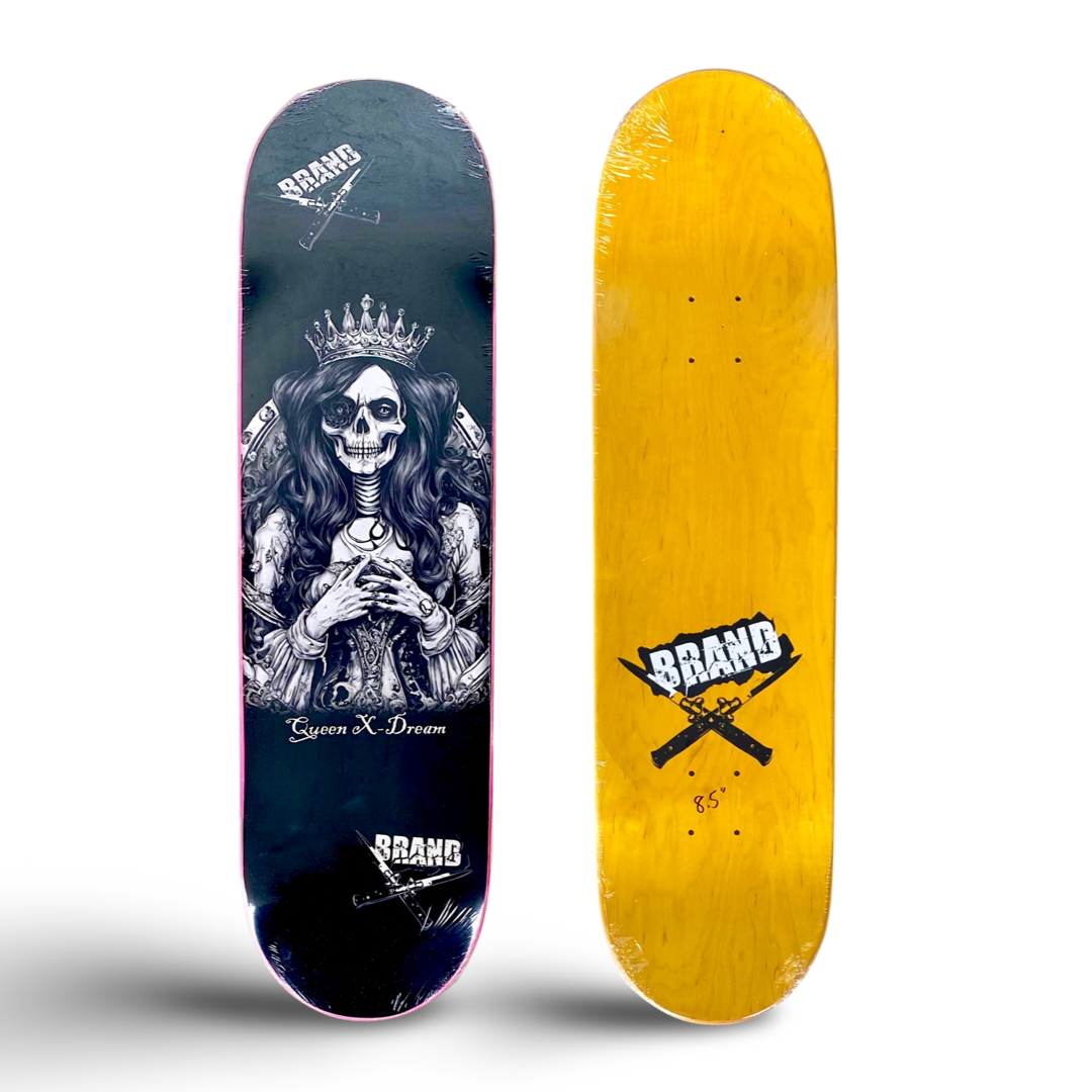 Brand-X Queen X-Dream skateboard deck: Black and white engraved-style skeletal queen with a crown, long wavy hair and clasped hands, framed by an ornate halo, with 'Queen X-Dream' beneath. Crossed flick knives Brand logos at top and bottom. Underside is yellow wood with a Brand logo.