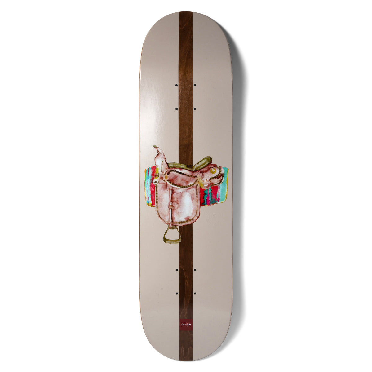 Chocolate Alvarez Save A Horse skateboard deck: A watercolour-style western saddle on a colourful striped blanket, centred over a dark brown wood-stained stripe running the length of the deck, on a pale taupe background.
