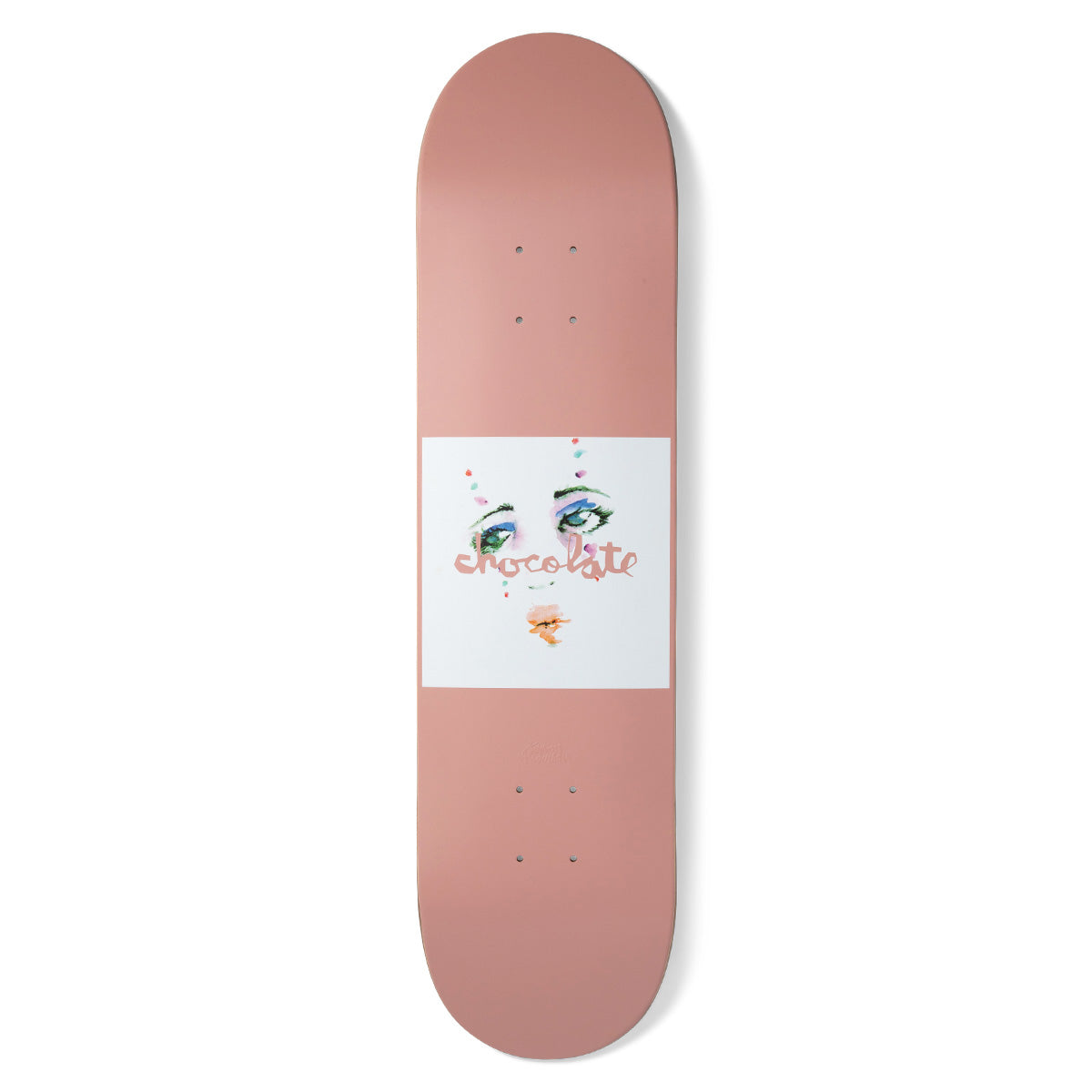 Chocolate Anderson Dream Rodeo skateboard deck: Plain dusty-pink deck with a white square at the centre showing a painted face of green eyes with colourful eyeshadow and lips, overwritten by the pink Chocolate script logo.