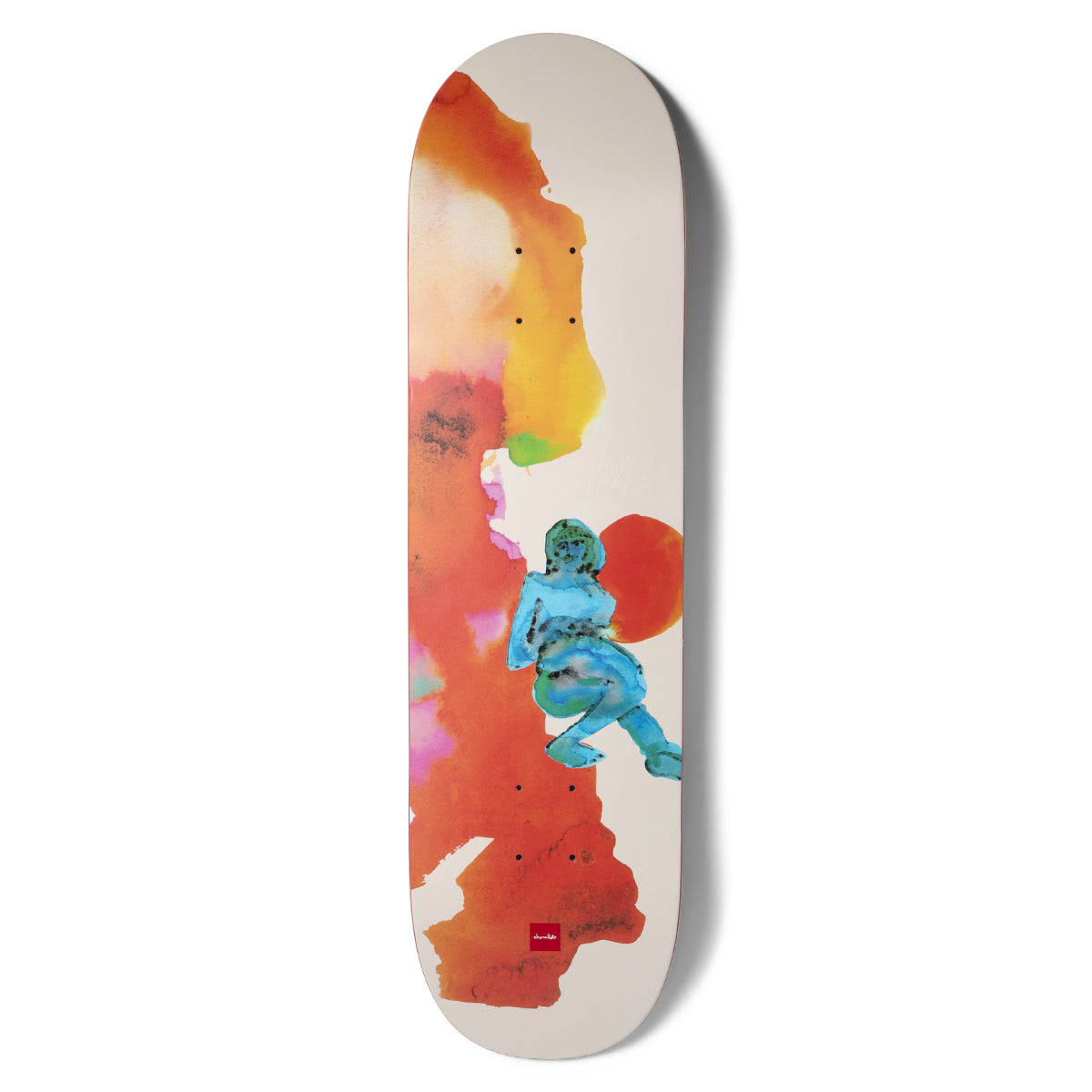 Chocolate Capps Dream Beach skateboard deck: Loose watercolour wash in orange, pink and yellow down the left side of a cream deck, with a small turquoise painted figure of a reclining woman and a red sun-like circle behind her.