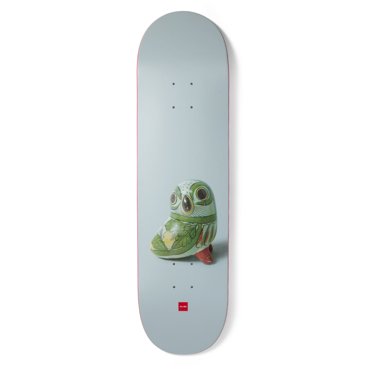 Chocolate Capps Porcelain skateboard deck: Photograph of a small green-glazed ceramic owl figure on a pale grey-blue deck, with the red Chocolate logo near the tail.