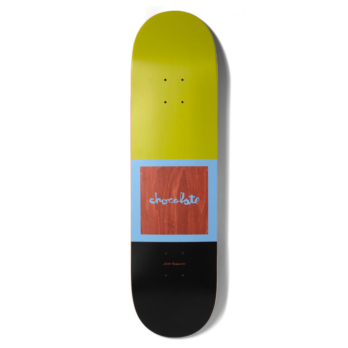Chocolate Fernandez OG Square skateboard deck: A colour-blocked design with olive green on top and black below. A light blue square frame holds a wood-grain panel carrying the brand's handwritten logo, with a small signature beneath.