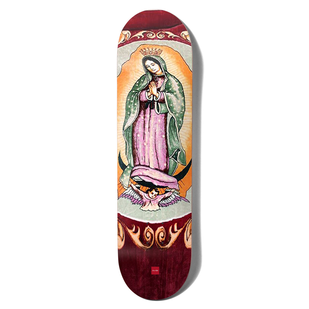 Chocolate Perez San Choco skateboard deck: Our Lady of Guadalupe style devotional image: a crowned praying figure in a green mantle and pink robe on an orange glow, supported by a cherub, framed by flame-like scrolls on a deep red ground.