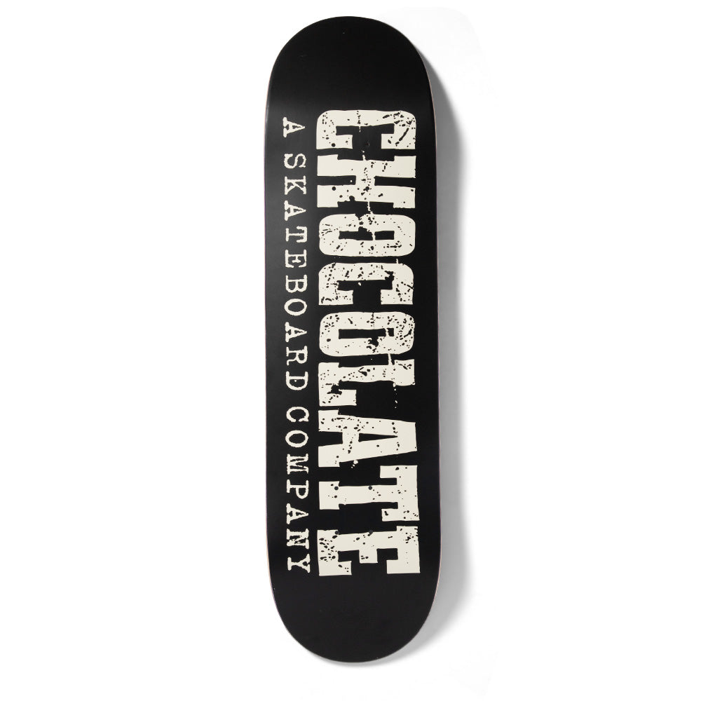 Chocolate Alvarez Western skateboard deck: Black deck with cream distressed slab-serif lettering spelling CHOCOLATE vertically, with A Skateboard Company in spaced-out typewriter capitals running alongside it.