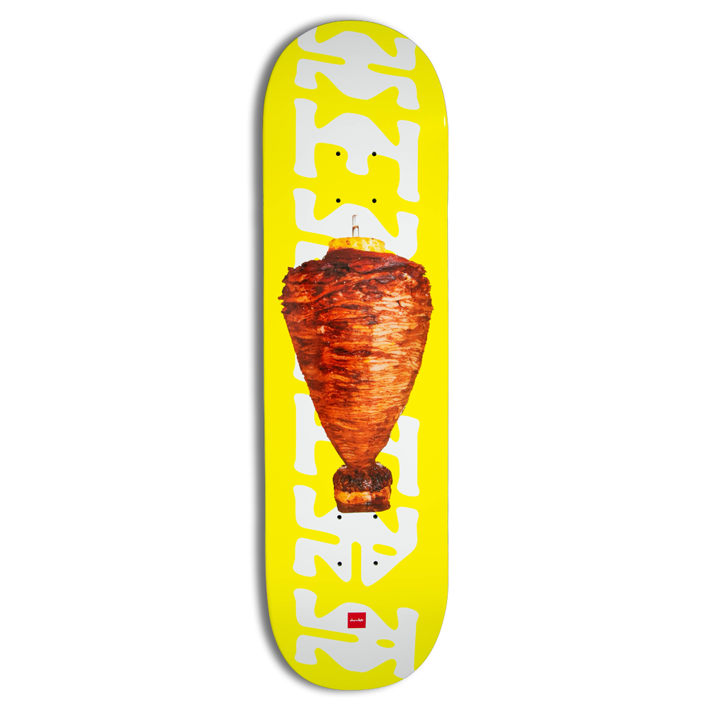 Chocolate Herrera Trompo skateboard deck: Photograph of a rotating spit of marinated al pastor meat topped with pineapple, centred on a bright yellow deck. Large wobbly white lettering runs up both edges.