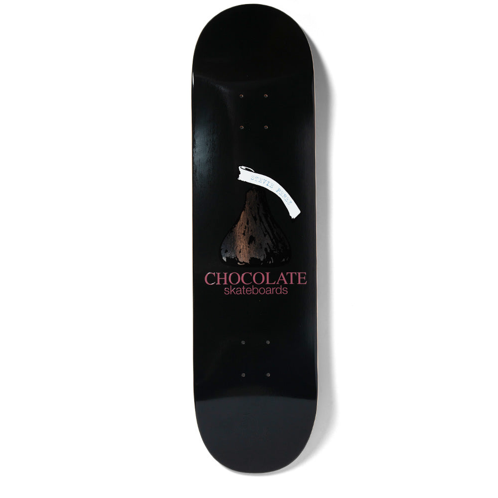 Chocolate Perez Kiss skateboard deck: Black deck with a chocolate kiss drawing, a white paper tag across its tip, and the Chocolate skateboards logo in dusty pink beneath.