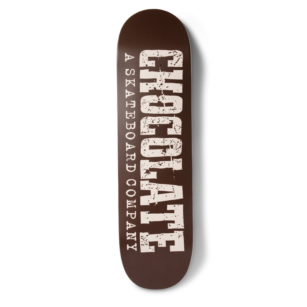 Chocolate Perez Western skateboard deck: Large distressed Western-style slab lettering spelling Chocolate runs the length of a brown deck, with 'A Skateboard Company' in smaller type alongside, all in cream.