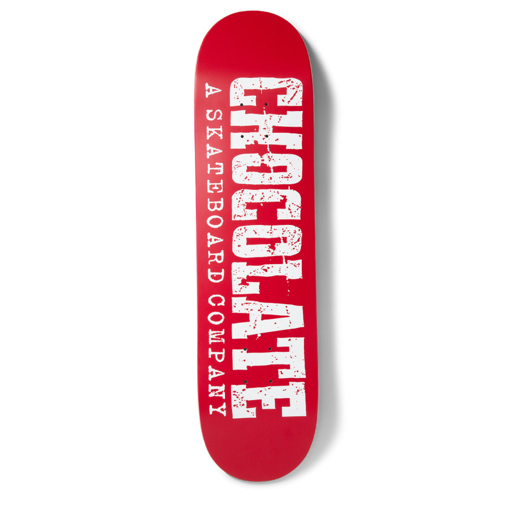 Chocolate Tershy Western skateboard deck: Large distressed Western-style slab lettering spelling Chocolate runs the length of a red deck, with 'A Skateboard Company' in smaller type alongside, all in white with red speckles.