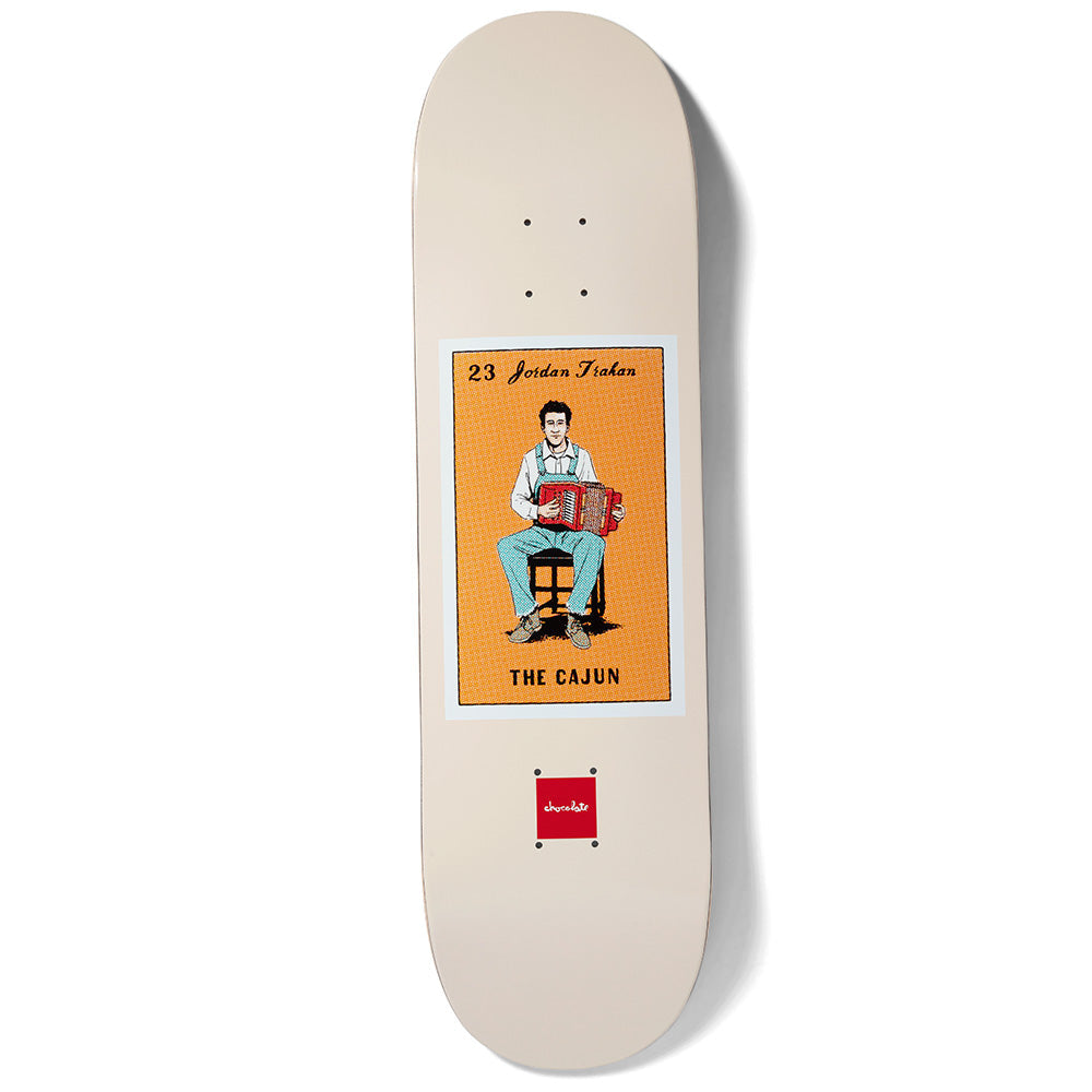 Chocolate Trahan Loteria skateboard deck: Cream deck with a Lotería-style card: a man in dungarees playing a red accordion on a stool, set on an orange panel. The card is numbered 23 and captioned The Cajun, with a small red Chocolate logo below.