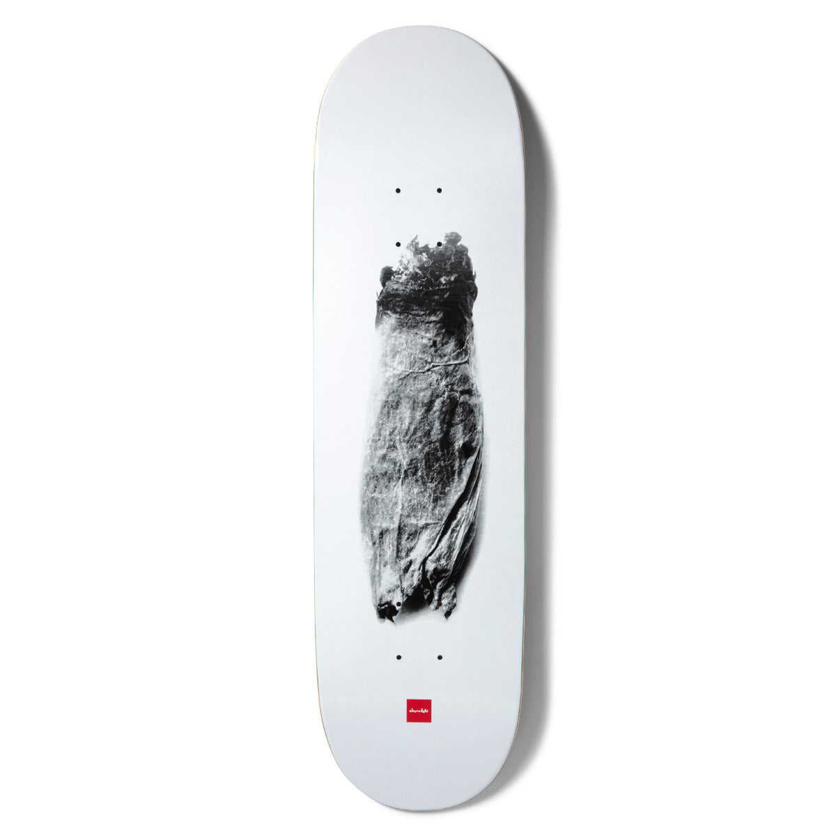 Chocolate Tershy Zorched skateboard deck: Grainy black and white photograph of a charred, scorched object resembling a burnt bundle, centred on a plain white deck with the small red Chocolate logo near the tail.