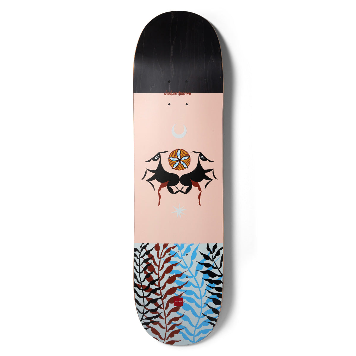 Chocolate Trahan Dog Perfume Pop Secret skateboard deck: Black-topped deck with a peach centre featuring two stylised black animals nose to nose beneath a flower emblem, moon and star, and a tail of black, red and blue leaf fronds.