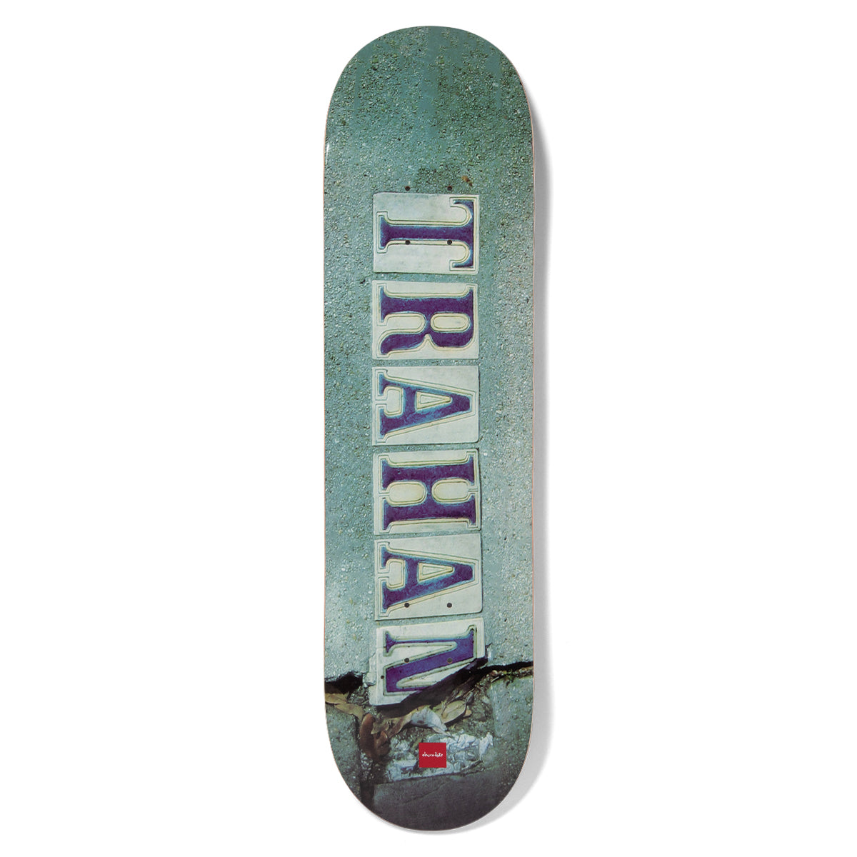 Chocolate Trahan French Quarter skateboard deck: Photographic image of a pavement with a row of old street-name tiles spelling 'TRAHAN' vertically in purple serif letters, with a crack across the concrete at the bottom.