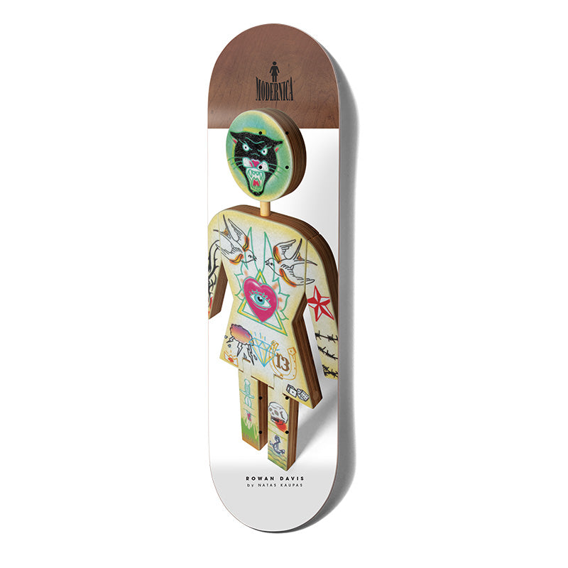 Girl Davis Modernica skateboard deck: Photograph of a wooden Girl figure with a panther-head face and tattoo-flash artwork on its torso: swallows, an eye in a heart, a diamond, stars and the number 13. Modernica logo on a brown wood nose, white lower deck.