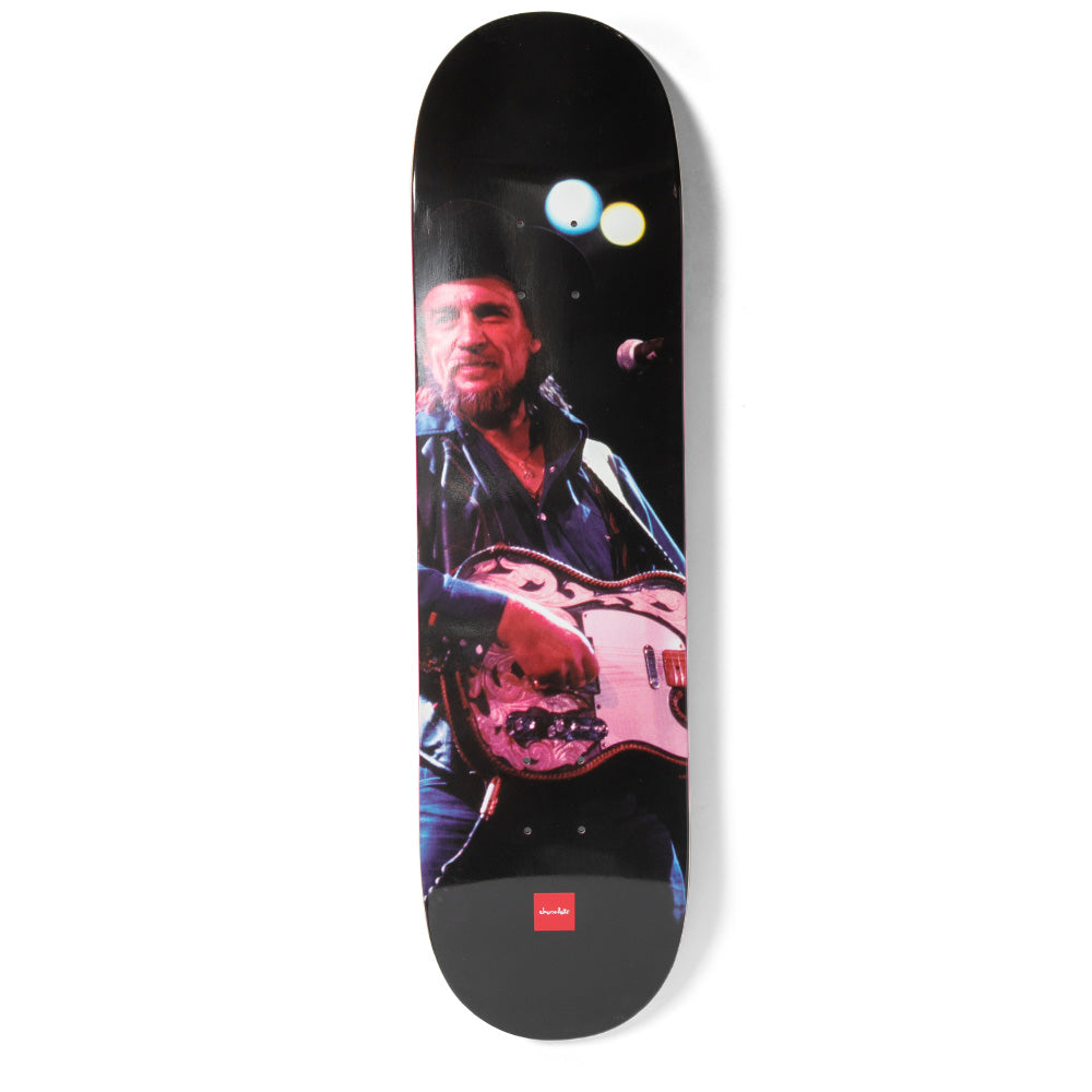 Chocolate Waylon Anderson skateboard deck: Live concert photograph of a bearded man in a black cowboy hat and leather jacket playing an ornately tooled guitar under stage lights, on a black deck with a small red Chocolate logo at the bottom.