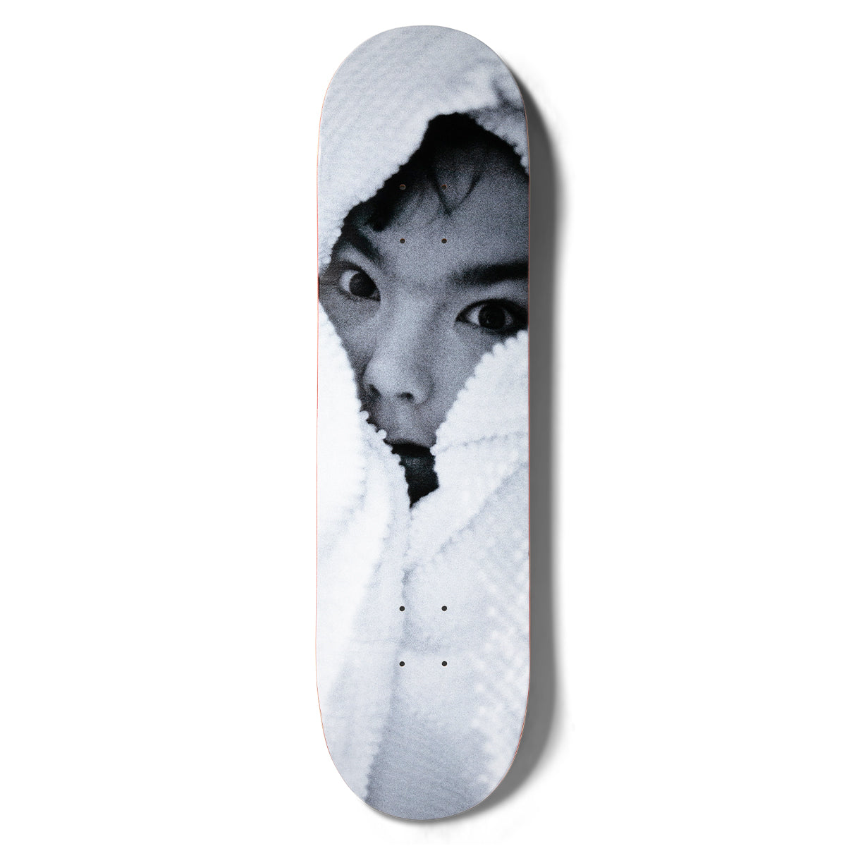 Girl Spike Photo Bjork skateboard deck: A black and white photographic close-up of a person's wide-eyed face peering out from a fluffy white towel or hood, filling the whole deck.