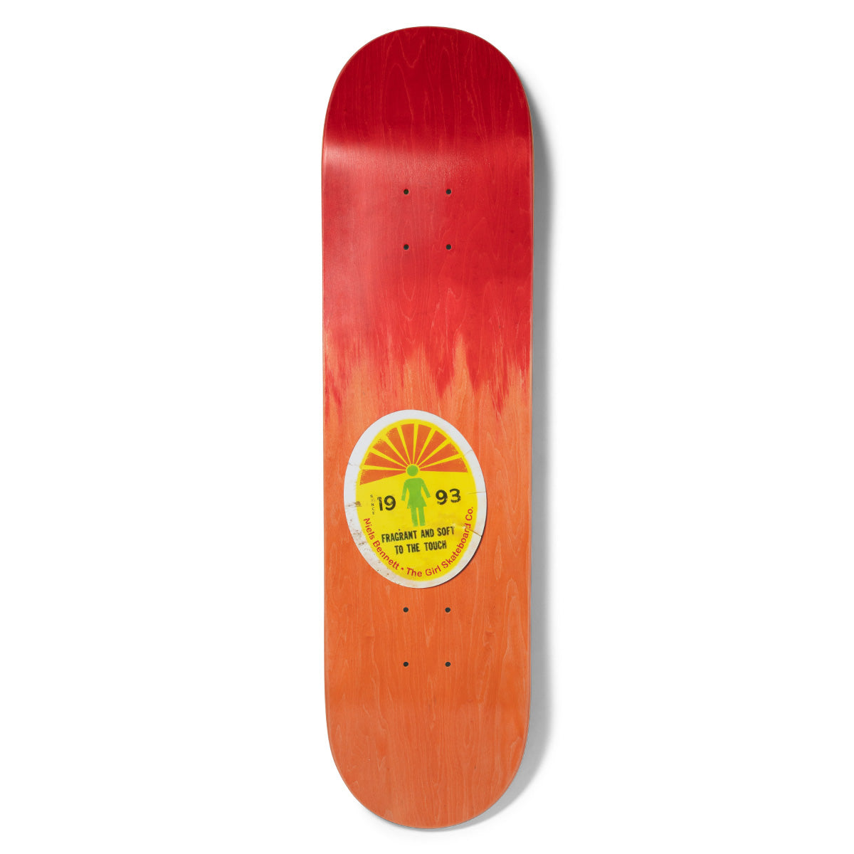 Girl Bennett Ripened skateboard deck: Peeling oval fruit-style sticker with a yellow sunburst, a green Girl figure and the text 19 93 FRAGRANT AND SOFT TO THE TOUCH, set on a red to orange faded wood stain.