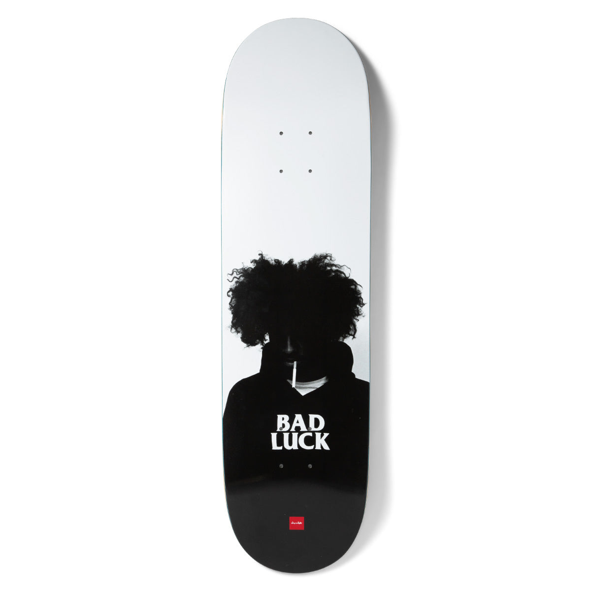 Chocolate Aikens Bad Luck skateboard deck: Black and white photographic silhouette of a person with a large curly afro and a cigarette in the mouth, face in shadow. BAD LUCK is printed in white on the dark chest, with a small red Chocolate logo at the bottom.