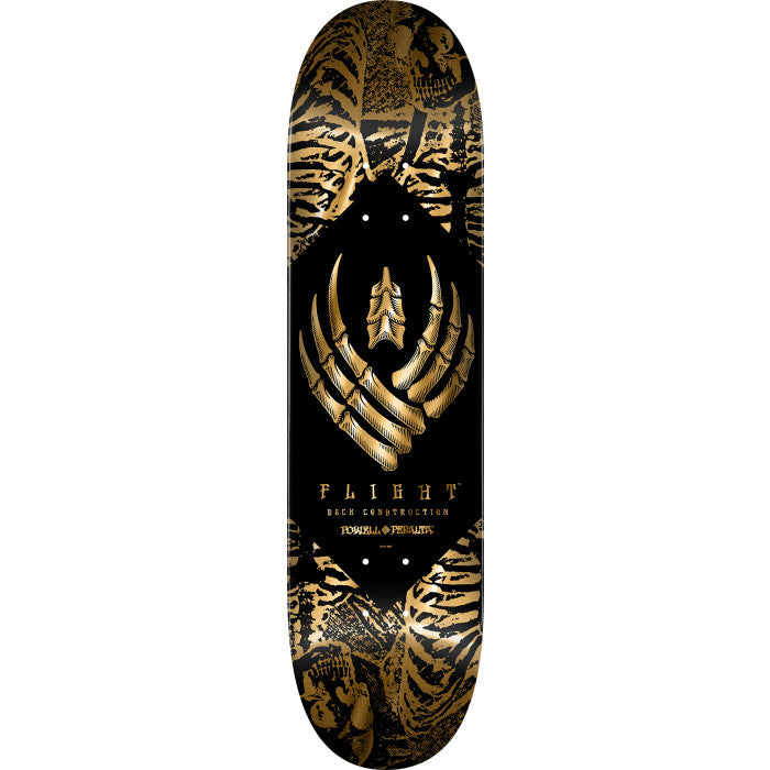 Powell Peralta Skeleton Gold Foil Flight skateboard deck: A skeletal bone-hand winged emblem in gold foil sits inside a black diamond, with a collage of ribcages and skulls in gold on black filling the corners. Flight text and Powell Peralta lettering run below.