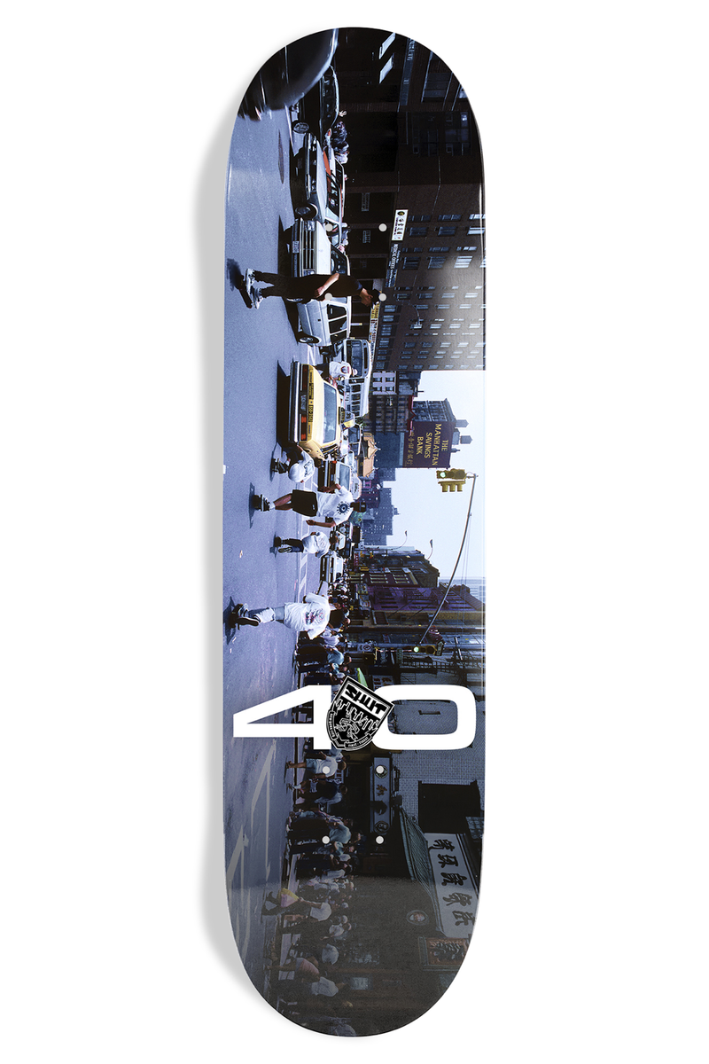 Shut Bryce Kanights Posse EX7 skateboard deck: Colour photograph of a New York street with a crowd and taxis, shot at an angle and filling the deck, with a large white number 40 and a small crest logo.