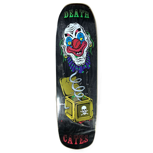 Death Skateboards Death Benson Devil Woman skateboard deck: Grinning clown head with a red nose and blue ruffled collar on a coiled spring, bursting out of an open yellow jack-in-the-box marked with a skull and crossbones. Black stained deck with Death and Cates in circus-style lettering.