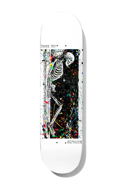 Deathwish Foy Only Dreaming Twin 8.5 skateboard deck: White deck with a tall black panel splattered with multicoloured paint, showing a white skeleton slumped against a tree trunk. Small handwritten rider and brand names run along the edges.