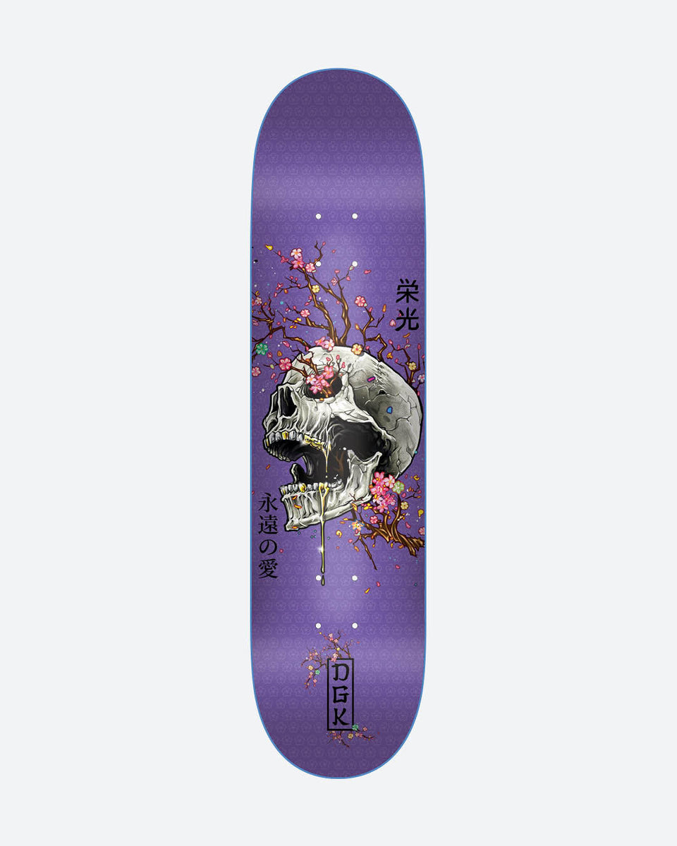 DGK Ancestry Purple skateboard deck: Large cracked skull with gold teeth dripping gold, entwined with pink cherry blossom branches, on a purple deck with a faint geometric pattern, Japanese characters beside it and a boxed DGK logo at the foot.