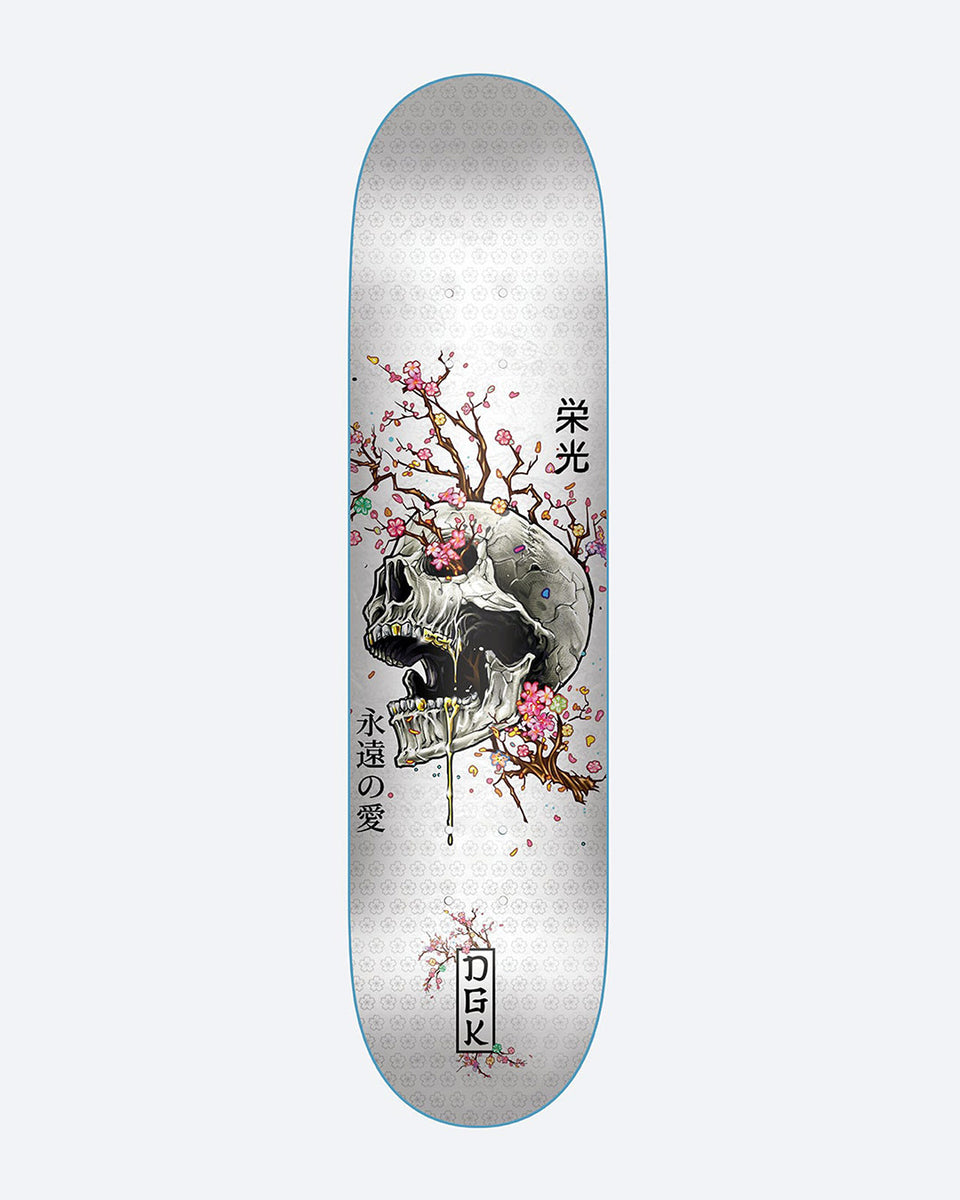 DGK Ancestry White skateboard deck: Illustrated white skull with gold teeth and cherry blossom branches growing from it, with Japanese characters beside it, on a white patterned deck. DGK logo in a box at the bottom.