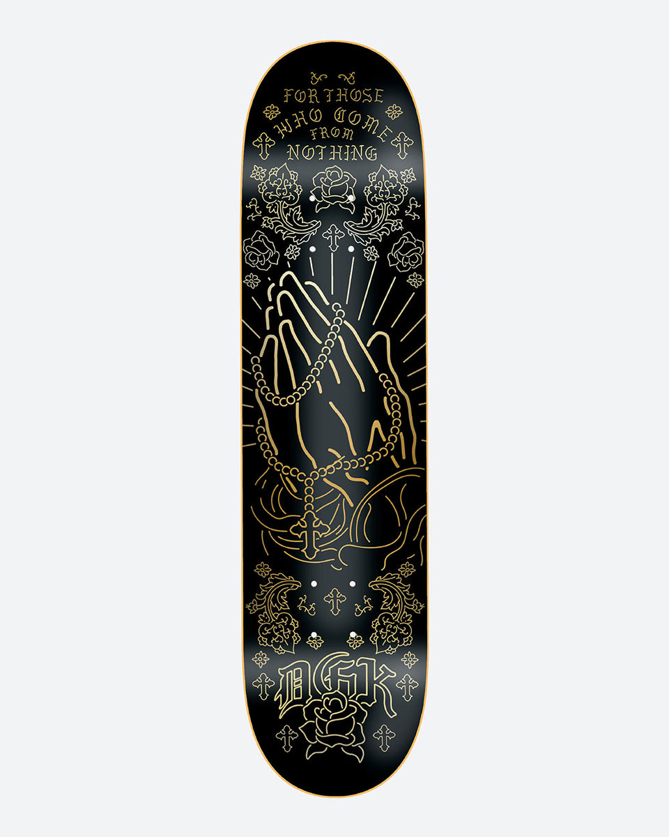 DGK Confession 8.5 skateboard deck: Gold line illustration on black of praying hands wrapped in rosary beads, with radiating lines, roses, crosses and ornate scrolls, and an old-English DGK logo at the base.