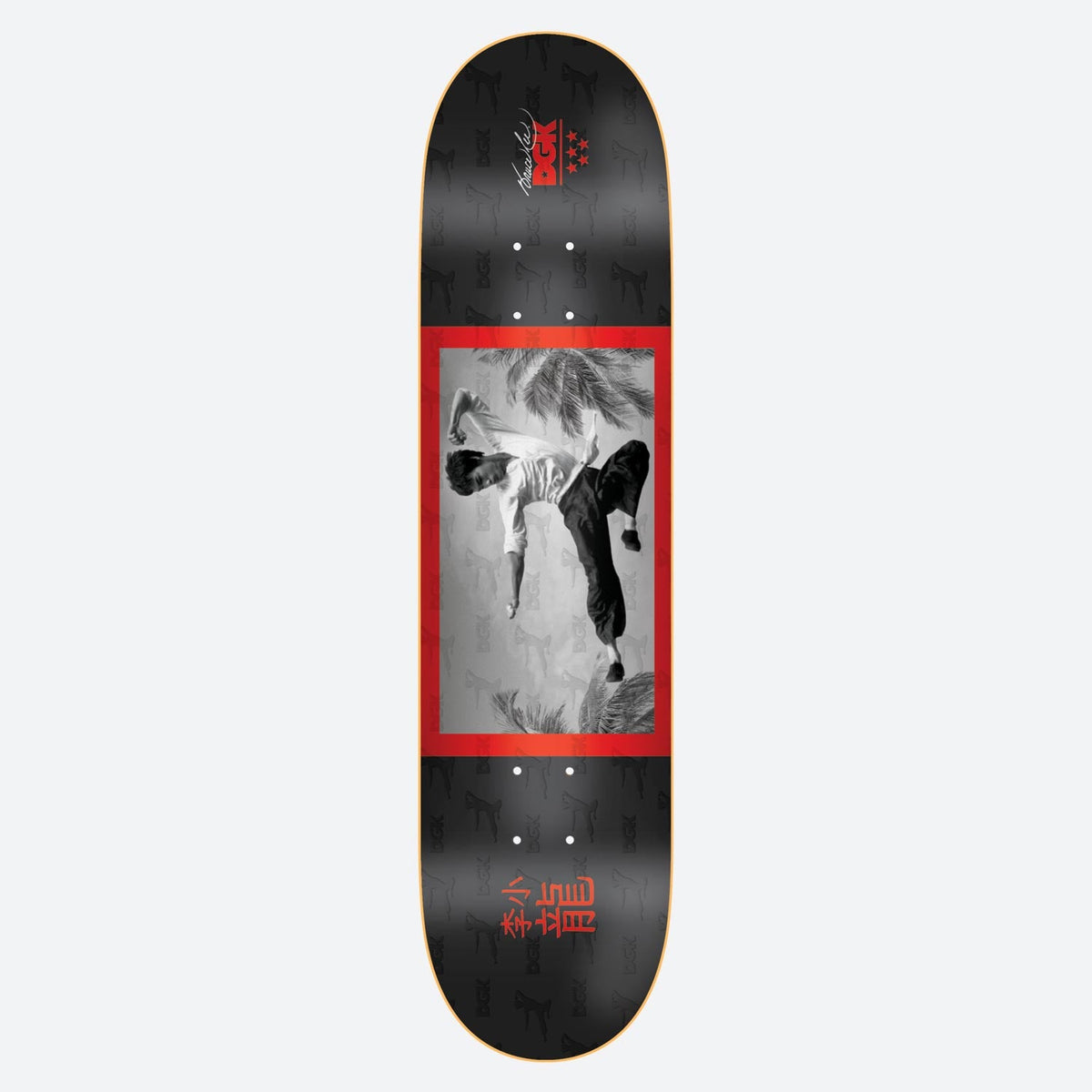 DGK x Bruce Lee Flying Man skateboard deck: Black and white photo of a martial artist in a flying kick among palm fronds, in a red frame on a black deck with a repeated faint pattern. Red Chinese characters at the tail and a signature with DGK logo at the nose.